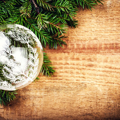 Fototapeta na wymiar Christmas Tree Branch on wooden background with festive glass b