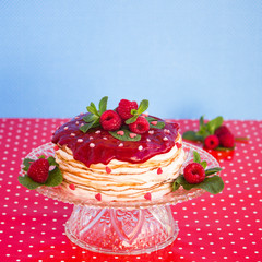 Delicious layered cake topped with raspberry and mint, blue