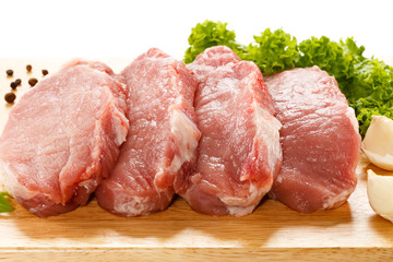 Raw pork on cutting board and vegetables