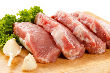Raw pork on cutting board and vegetables