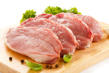 Raw pork on cutting board and vegetables