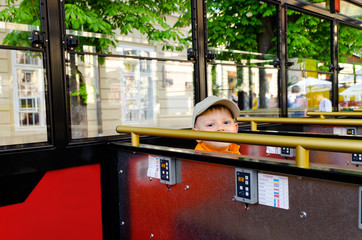 Cute little boy riding in a bus or tram