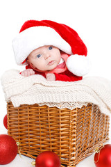 little cute baby with santa costume lying in basket