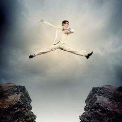 Businessman jumping over gap