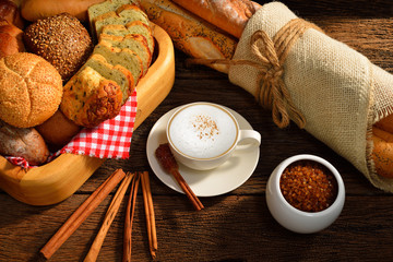 A cup of cappuccino and bread.
