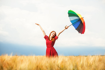 Redhead girl with umbrella at field