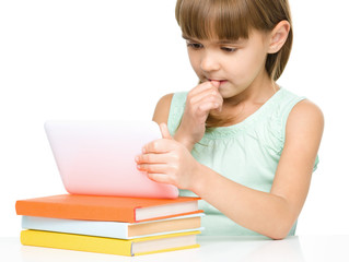 Young girl is using tablet while studying