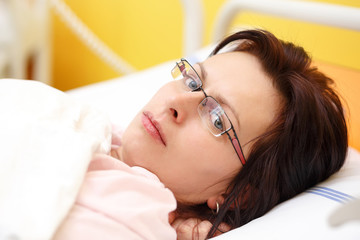 Obraz na płótnie Canvas sad middle-aged woman lying in hospital