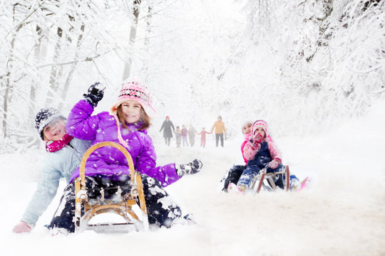 Happy family winter fun outdoors. Active parents with kids runni