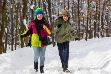 Fototapeta na wymiar Girl and boy running in winter park