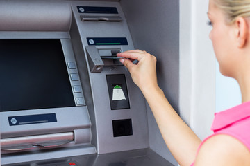 Young woman using a ATM