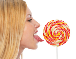 Profile portrait of teenage girl licking lollypop