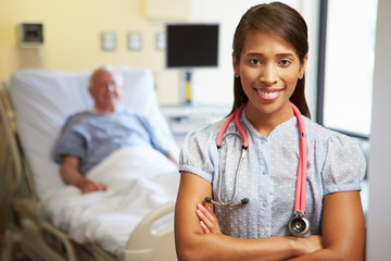 Portrait Of Female Doctor With Patient In Background