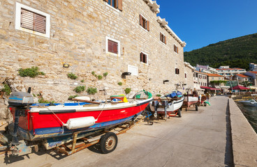 Fototapeta na wymiar Red fishing boat stands on the coast