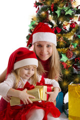 Fototapeta na wymiar Mother and little daughter with presents under Christmas tree