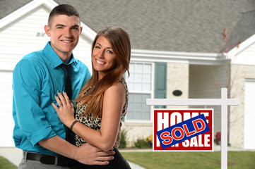Happy Couple if Front of Newly Sold Home