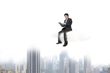 Businessman using tablet and sitting on cloud