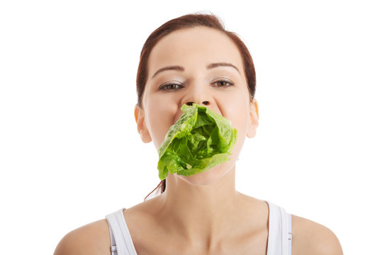 Beautiful Woman With Leaf Of Lettuce In Mouth.