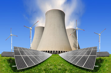 Solar panels before a nuclear power plant and wind turbines