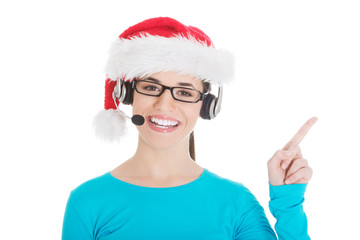 Young casual woman in santa hat and,microphone and headphones.