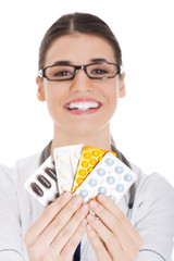 Young female doctor holding pills.