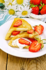 Pancakes with strawberries and cream on the board