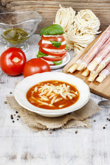 Italian cuisine: tomato soup, breadsticks with ham, caprese sala