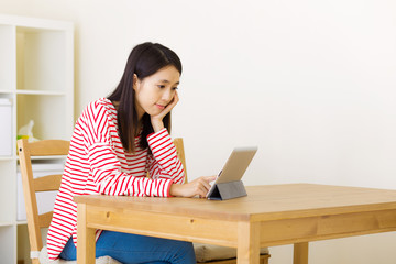 Asian woman watching movie on digital tablet