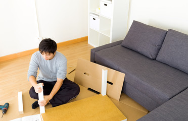 Asian man assembling table