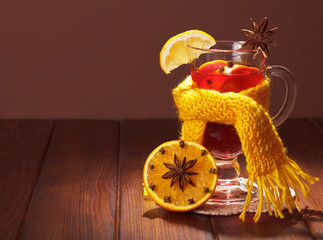 Glass of mulled wine in scarf and spot light