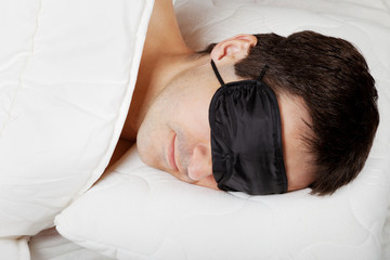 Man with Sleeping mask sleep lying in bed