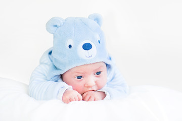 Adorable newborn baby boy in a blue teddy bear hat