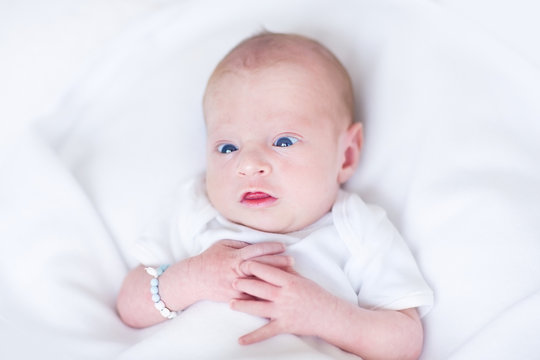 Funny newborn baby on a white blanket