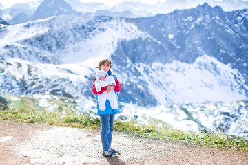 Obraz premium Little boy playing with his newborn baby brother in the mountain