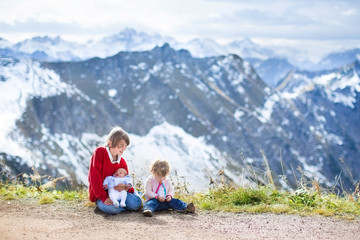 Fototapeta na wymiar A teenager boy, toddler girl and newborn baby in mountains