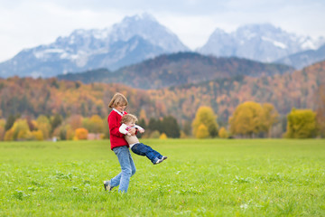 Happy kids, a teenager boy and his baby sister in mountains