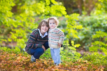 Fototapeta premium Adorable baby girl and her teen age brother playing together in