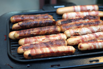 Grilling bacon wrapped sausages