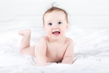 Little baby girl with beautiful big eyes playing on her tummy