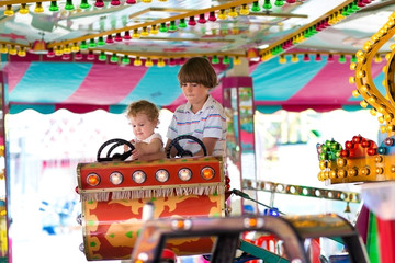 Brother and his baby sister on a ride in an amusement park