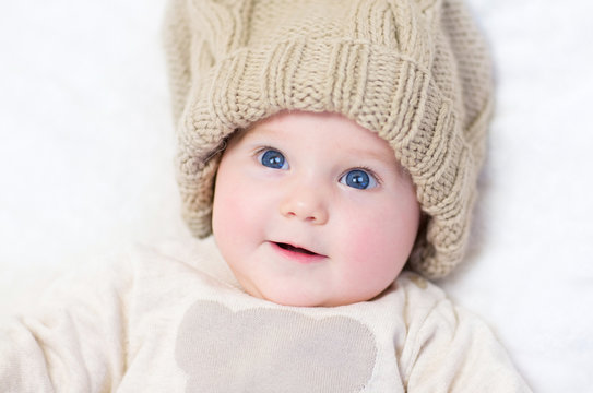 Cute newborn baby wearing a big knitted hat and a wam sweater