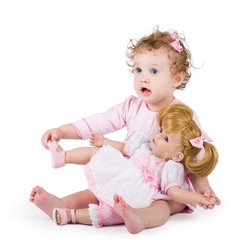 Cute toddler girl playing with her first doll