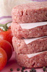 four raw hamburger and tomato
