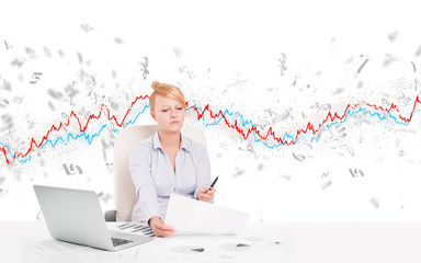 Business woman sitting at table with stock market graph