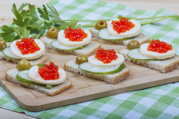 Sandwiches of white bread with fresh cucumber, cheese,  salmon c