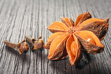 Anise stars and cloves on wooden background