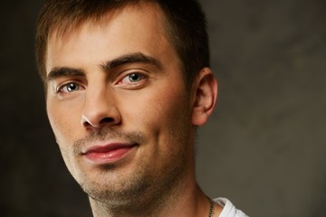 Handsome young man in white t-shirt on grunge background