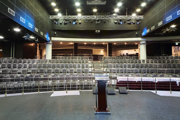 Document stand and table on stage and rows of seats