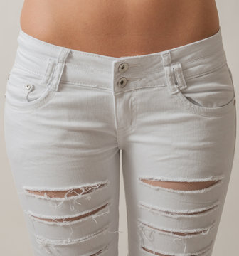 Attractive young woman in white ripped jeans