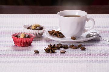 Cup of coffee decorated beans and anise with fresh cakes